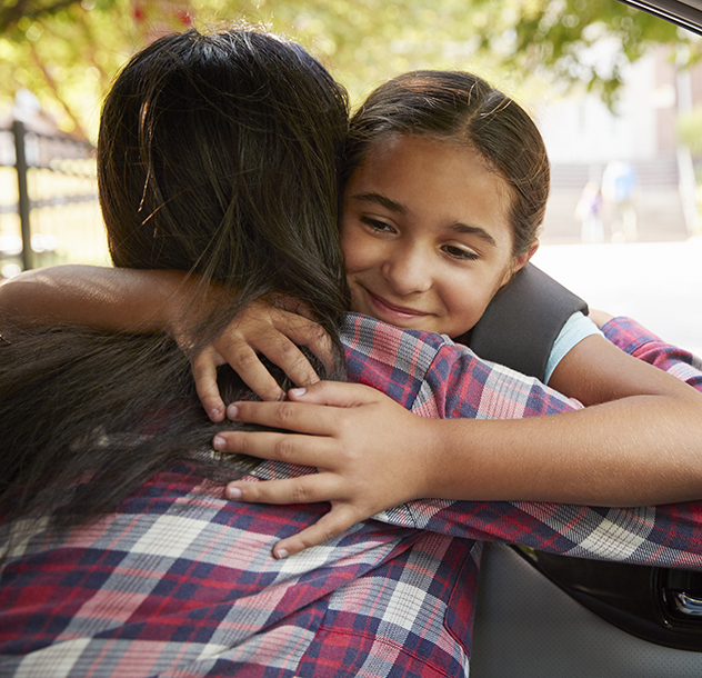 girl-hugs-mother-through-car-window